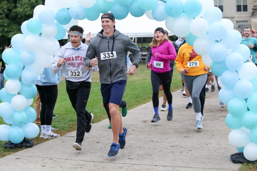 Participants run threw the balloon arch to start the 4k for the Kids run/walk Sunday morning on Central Campus.