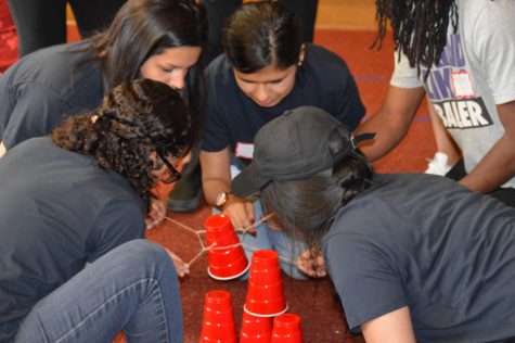 Members of the Multicultural Business Club work together to complete their task at Thursday nights showdown. The objective of this task is to stack the cups using only a string and a rubber band. This event was the Student Organization Showdown held in the Campanile Room of Memorial Union on Thursday night.