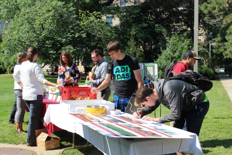 People gather around to get free cookies, apples and to enter the giveaway for a free dinner for two in the East Marston Lawn on Sept. 10. 