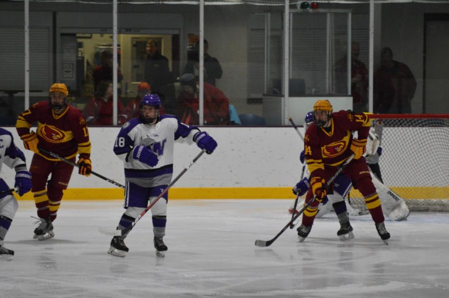 Cyclone Hockey players watch the puck and decide their next move at Friday nights game. The team played Waldorf University at the Ames ISU Ice Arena. 