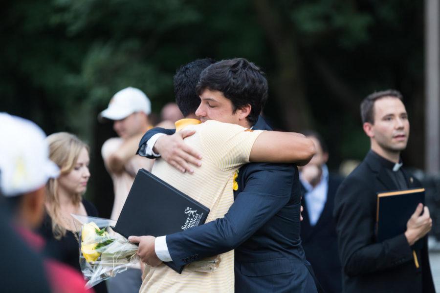 Calros Negrin Bolanos (right), boyfriend to Celia Barquín Arozamena, hugs former member of the mens golf team (Left) before the start of the candlelight vigil Sept 19. 