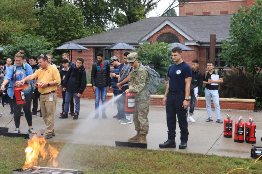 Senior Tyler Pasut, extinguishes the controlled fire set by the local fire department outside of Parks Library Sept 19. 