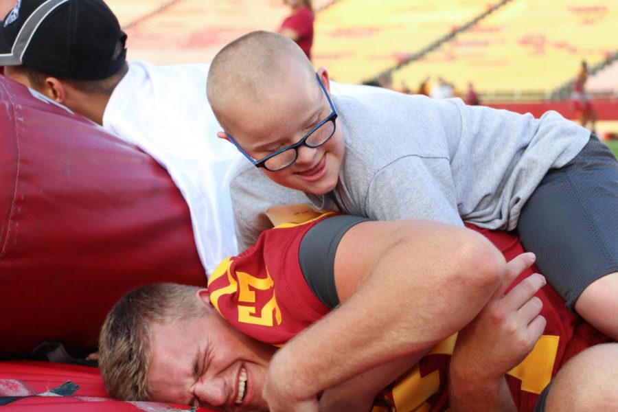 Jack Land tickles offensive lineman Colin Newell during Victory Day on Friday, Aug. 25, 2017. Victory Day gives children with disabilities the opportunity to meet and participate in drills with Cyclone football players.