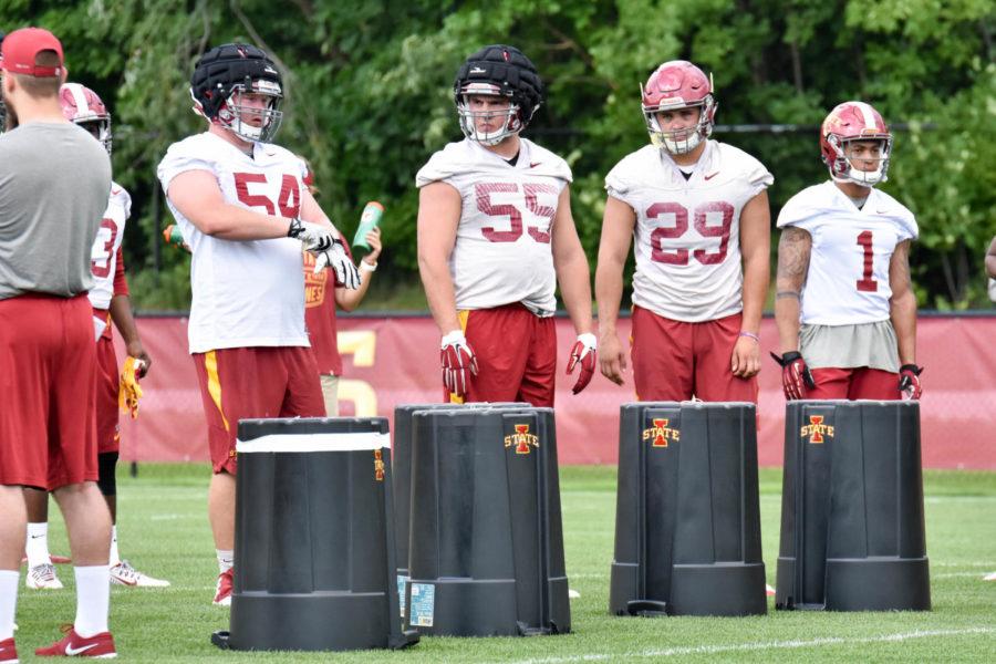 ISU football players Collin Olson, J.D. Waggoner, Kane Seeley and DAndre Payne wait for a play at practice on Aug. 4, 2016.