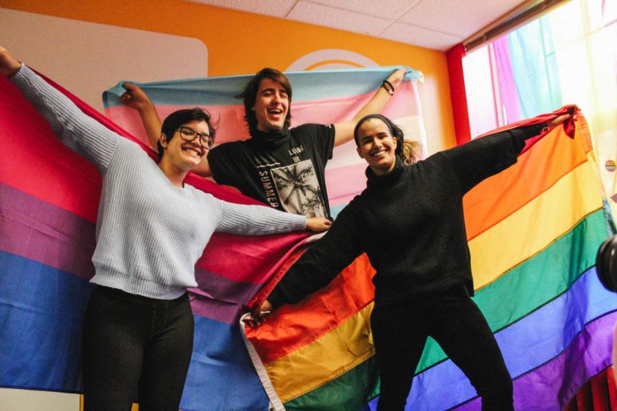 Daniela Ortiz (left) holds a Bi pride flag, Alex Zafra (center) holds a Trans pride flag, and Iris Barreta (right) holds a Gay pride flag for the National Coming Out Day photoshoot at The Center on Oct. 11. The month of October is LGBTQIA+ History Month.