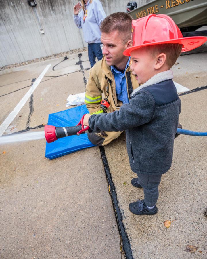 Scout Reimers, 3 years old, uses the fire hose at the Ames Fire Departments 6th annual open house on Oct. 13.