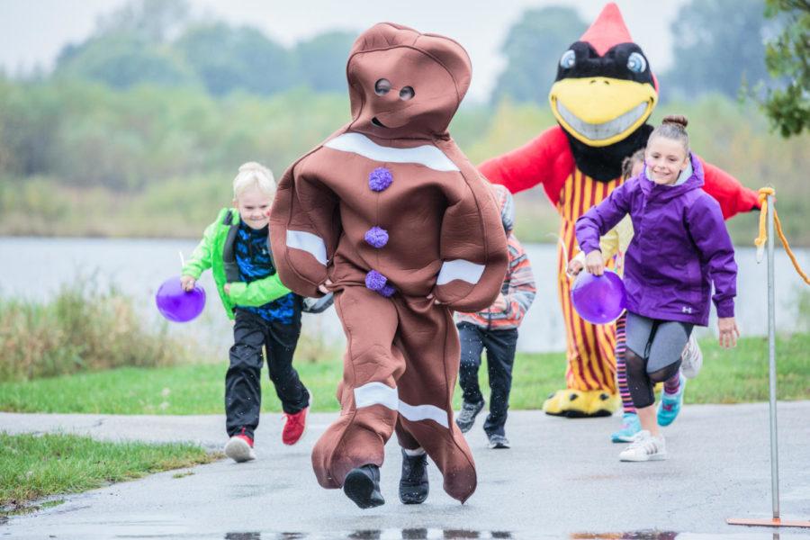 Cy and the Gingerbread Man compete against kids in the preliminary foot race at the Gingerbread 5K at Ada Hayden in Ames on Oct. 7.