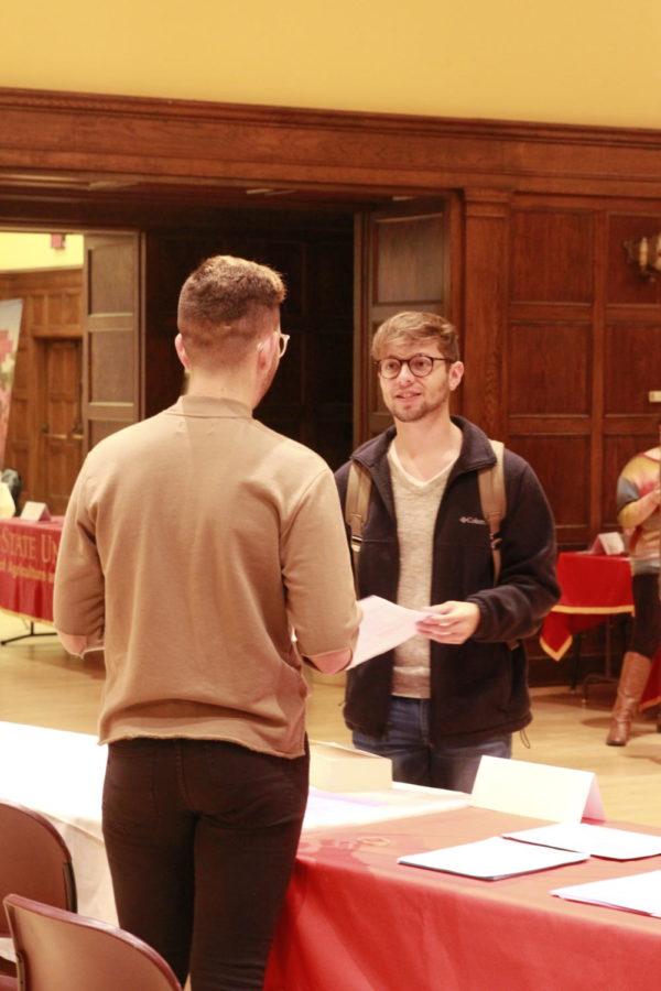 Alec Norem (Left), a senior in Advertising, talks to a student about the Greenlee School Journalism and Communication. His colleague Claire Norton, a senior in Public Relations, cites a unique culture and a friendly environment as great reasons to join their college.