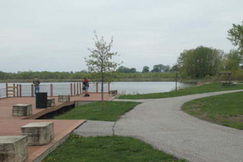 Parkgoers fishing at Ada Hayden Heritage Park. The park is home to two lakes, which are used for activities such as fishing and boating. 
