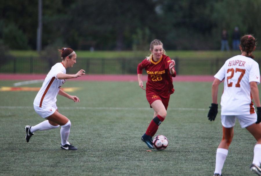 Midfielder Taylor Wagner tries to keep the ball out of reach from a University of Texas player during their game at the Cyclone Sports Complex on Oct. 5. The Cyclone lost 2-1 after playing the first half in the rain.
