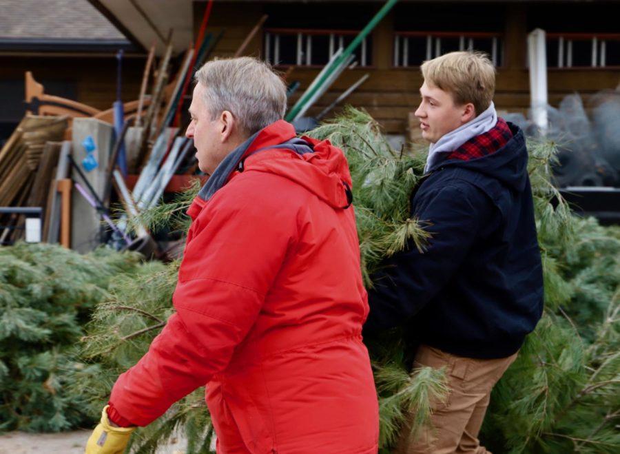 Ben Wilson (right), junior in forestry, helps carry a Christmas tree to Charles Hurburgh's (left) car, on Nov. 29 for the Forestry Club's fundraiser in the Reiman Gardens parking lot.