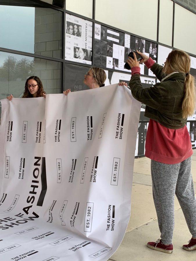 Producers and directors of the Fashion Show setting up a backdrop for photography at the Fashion Show's rebrand launch event.