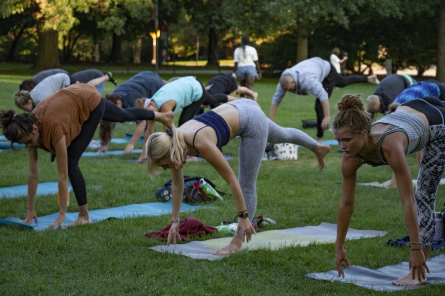 Students, faculty and community members gather to do yoga on the lawn in front of the Campanile on Aug 30 as a part of the Live Green! Initiative and its partnership with ISU Recreation Services. 