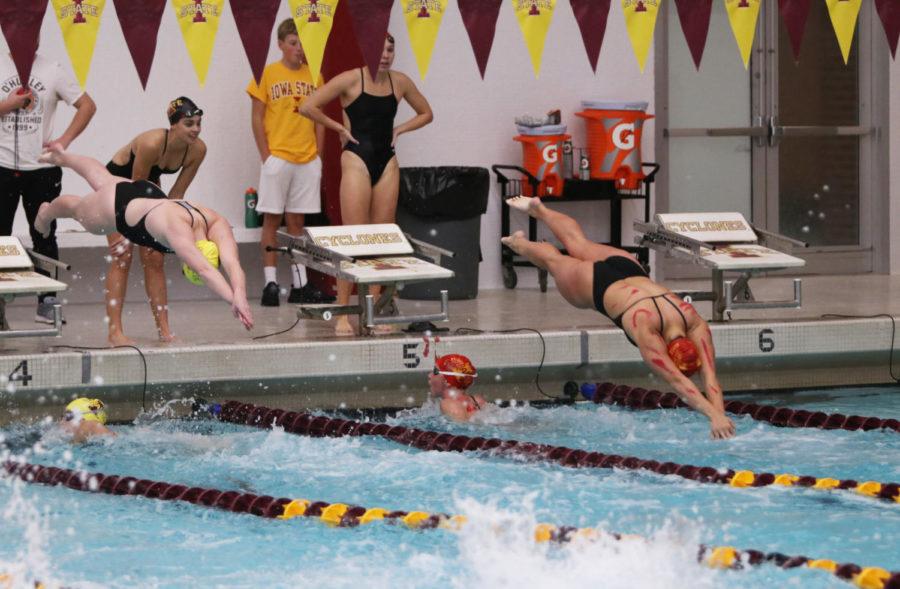 Members of the Iowa State swim and diving team compete in a relay race during the Cardinal and Gold swim meet at Beyer Hall on Oct. 12.