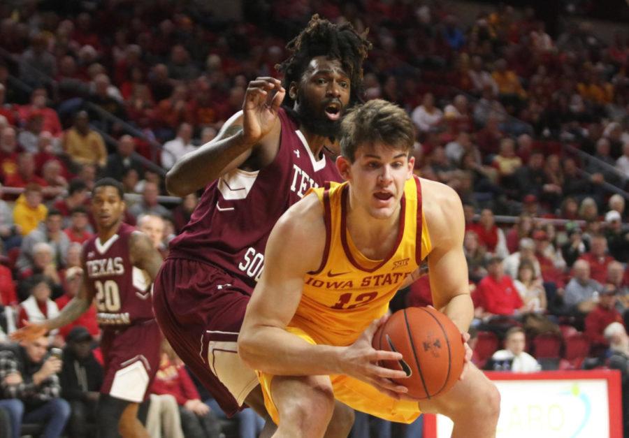 Redshirt junior Michael Jacobson keeps the ball out of reach from Texas Southern senior Jeremy Combs during the game against Texas Southern at Hilton Coliseum on Nov. 12. The Cyclones won 85-73.