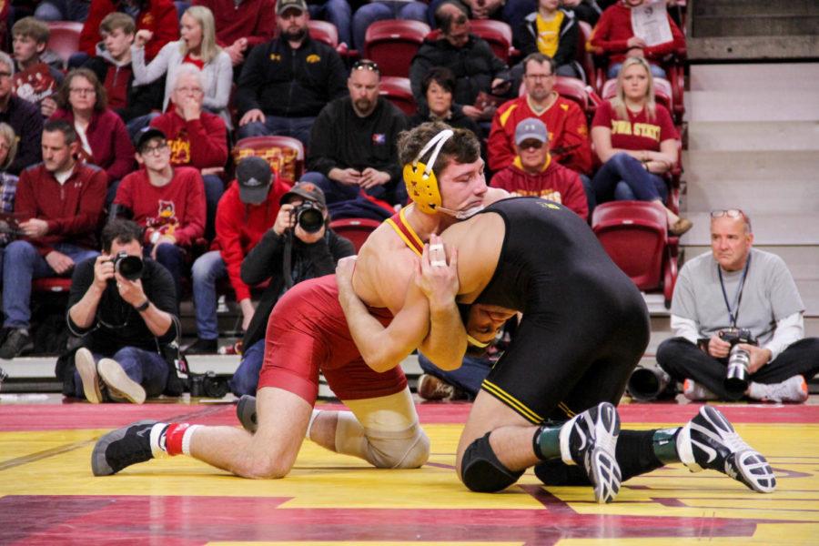 Sophomore Chase Straw wrestling a Hawkeye opponent during the CyHawk dual meet on Feb. 18 at the Hilton Coliseum. 