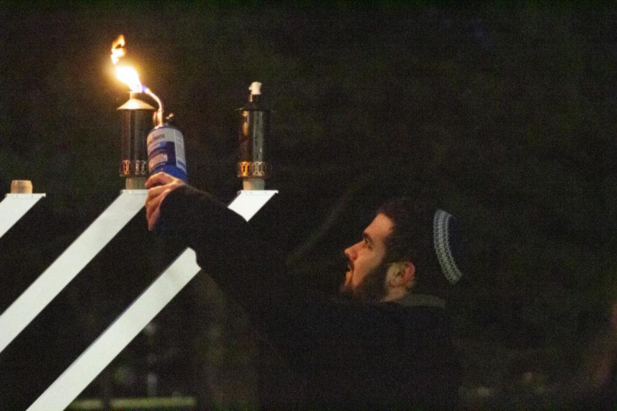 Joseph Bingham, president of Chabad on Campus, lights the six-foot menorah in front of Parks Library on Dec. 3. Bingham created a petition to get a “campus Rabbi.” Bingham got this idea after a conversation he had with other students and he wants to bring more representation to the Jewish community. 