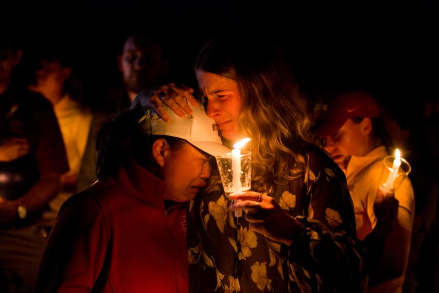 Amelia Grohn grips fellow members of the Iowa State Womens Golf Team as they mourn their teammate Celia Barquín Arozamena during the candlelight vigil held in her honor Sept 19.