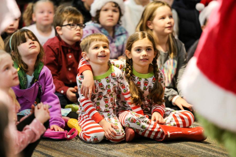 Children sit and listen as the Grinch reads during a story time event hosted by the Iowa State University Book Store on Dec. 1. Children were given coloring pages and Grinch t-shirts were available during the event. Children were also able to take photos with the Grinch.