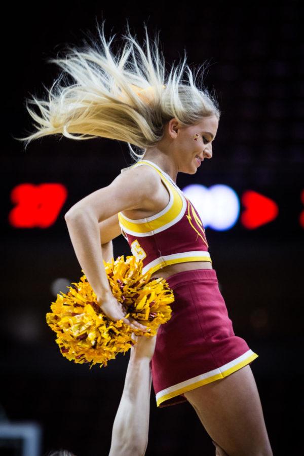 A member of the Iowa State Cheer Squad comes down from a stunt during the Iowa State vs Texas Tech womens basketball game Jan. 29 in Hilton Coliseum. The Cyclones defeated the Red Raiders 105-66.