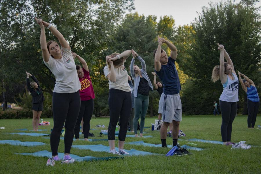 Molly Breen, Madeleine Blandin, Sam Kunde and Alice Kenawell follow the instructors directions as the participate in the Yoga on the Lawn event held by a partnership between the Live!Green Initiative and the ISU Recreation Services.