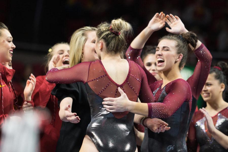 Assistant Coach Kristin White and Junior Meaghan Sievers hug Sophia Steinmeyer after she completed her beam routine during the Iowa State, Iowa and Missouri tri-meet. the cyclones won with a team score of 196.700 points.  