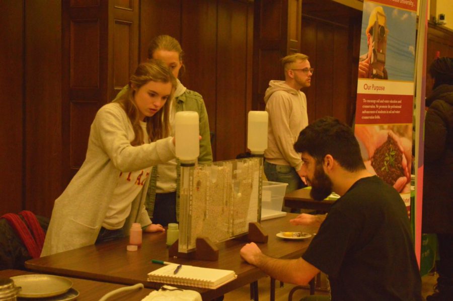 Members of the soil and water conservation club show Hector Arbuckle, senior in biology, what their program is trying to help solve. The club had a table at the Sustainability Poster Session held Tuesday in the Great Hall of the Memorial Union.