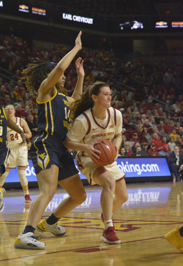 Iowa State redshirt senior Alexa Middleton defends the ball from West Virginia University freshman Kari Niblack in the first quarter of the game before passing to a teammate. The Cyclones won 77-61 against the Mountaineers at Hilton Coliseum on Feb. 9.