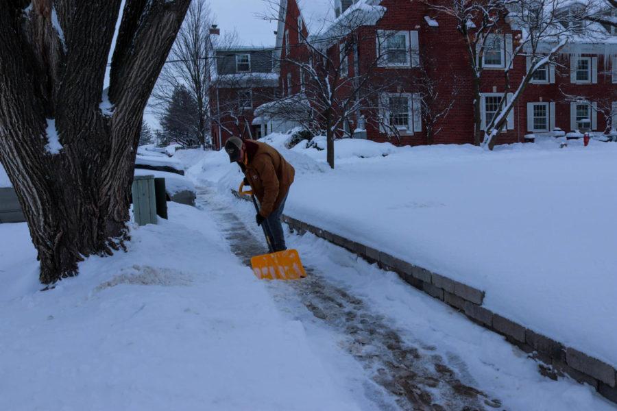 Alec White, a senior in Kinesiology and a member of Delta Tau Delta fraternity, helps shovel the sidewalk outside the Pi Beta Phi sorority house. Ames is forecasted to get more snowfall over the weekend. 