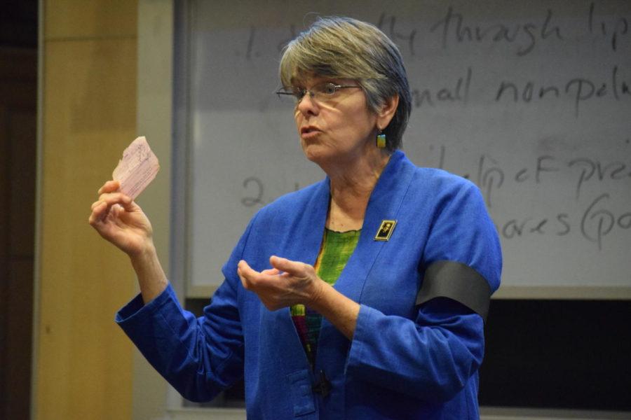 Mary Beth Tinker holding her original detention slip after she wore a black armband to school to protest the Vietnam War (with a replica on her left arm) during a speech at Textor Hall, Ithaca College, 19 September 2017.