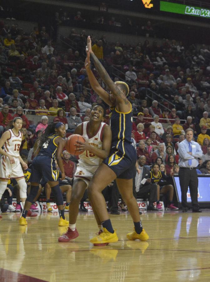 Iowa State senior Inès Nezera looks to shoot a basket while being defended by West Virginia University senior Theresa Ekhelar during the second quarter of the game at Hilton Coliseum on Feb. 9. Nezera was successful in making the basket. The Cyclones won 77-61 against the Mountaineers.