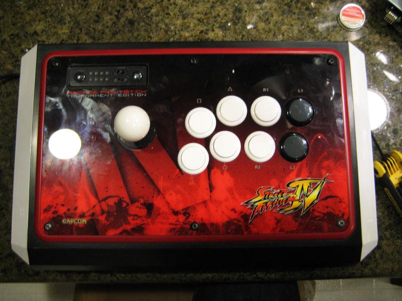 An arcade fight stick with Super Street Fighter IV branding. Fight sticks have larger buttons and joysticks, making it easier for gamers with physical disabilities to use.