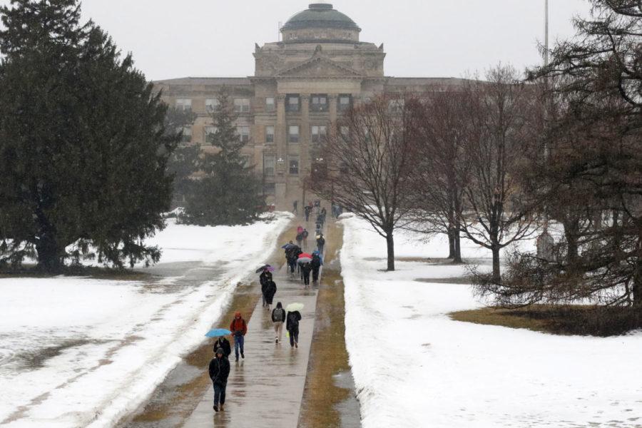 Students walk to class in the rain on Mar. 13. Due to the rain and melting snow, Story County was under a flood warning.