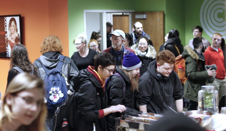 Students and community members eat food during the re-opening of the Center for LGBTQIA+ Student Success March 5 at 3224 Memorial Union. Attendees were given a tour of the new space. 