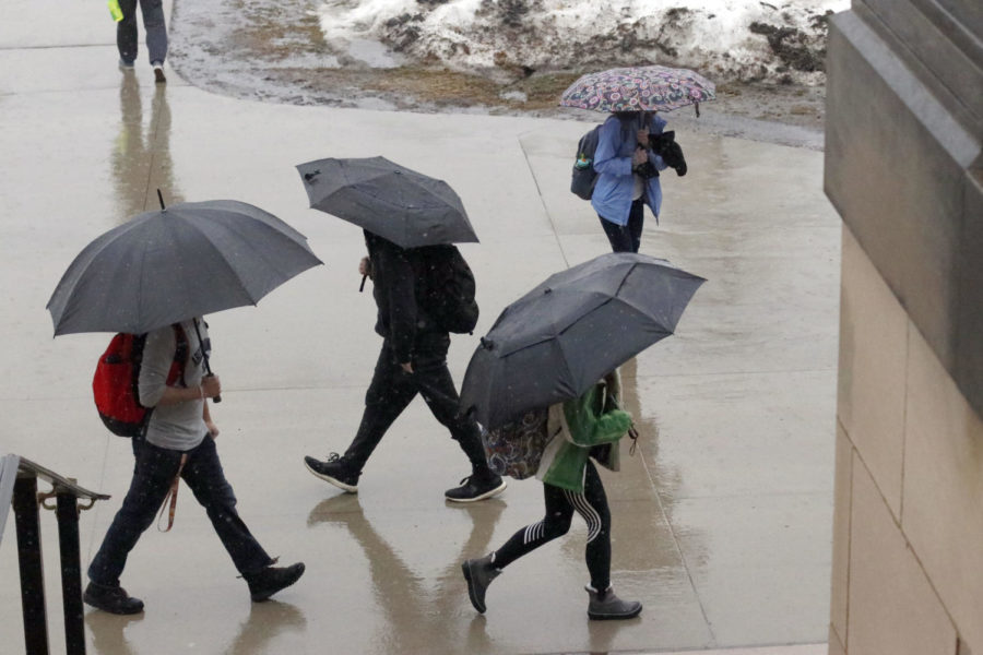 Students walk to class in the rain on Mar. 13. Due to the rain and melting snow, Story County was under a flood warning.