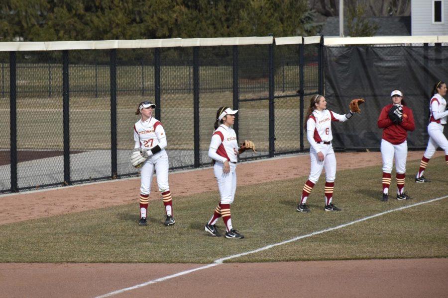 Members of the Cyclone Softball team warm up before an inning March 29.