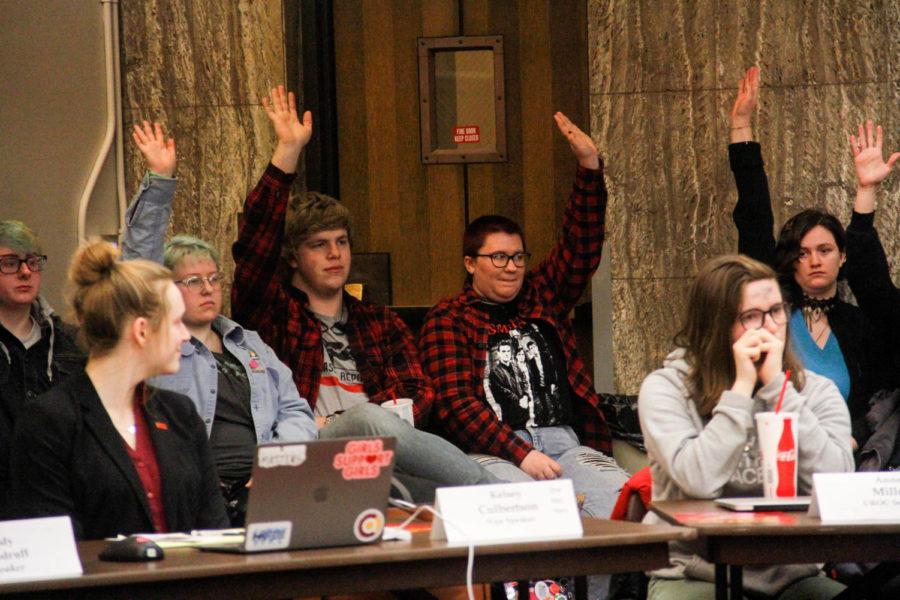 Members of the LGBTQ+ community raise their hands for recognition during their sit in protest of student governments Senate Study Bill 1099 during the student government meeting on March 6 at the Memorial Union. 