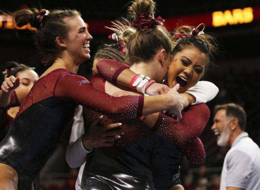 Iowa State gymnasts Meaghan Sievers (left) and Sydney Converse (right) congratulate teammate Annie Johnson after she competes exhibition style on the bars during the meet against Southern Utah University at Hilton Coliseum on Feb. 8. Iowa State won with an all-around score of 195.375, beating out Southern Utah with a score of 195.250. Iowa State had higher scores then Southern Utah in vault, bars, beam and floor.