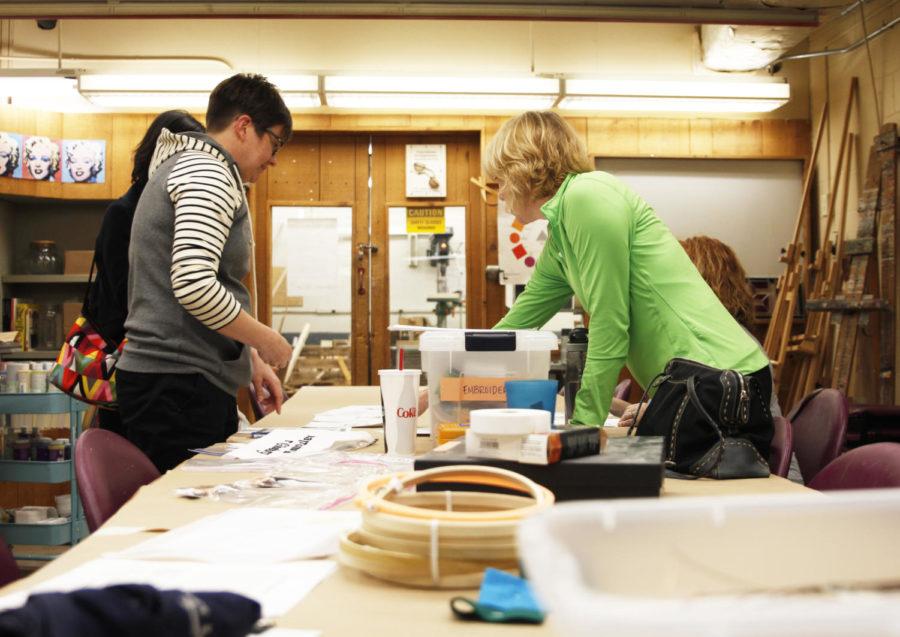 Cross stitch workshop instructor, Amy Bannister, helps attendees choose patterns for the feminist cross stitch project in the Memorial Union Workspace Tuesday, March 26.
