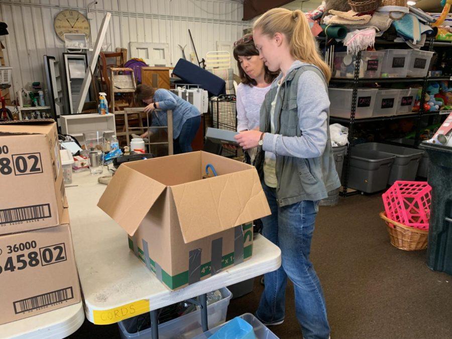 Amanda Schuler, a volunteer at Overflow, sifts through donations to sort products into correct departments such as clothing, home decor and others.