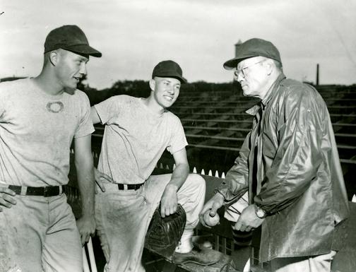 Players on the 1957 team Dick Bertell, left, and Gary Thompson talk with Coach Cap Timm, right.
