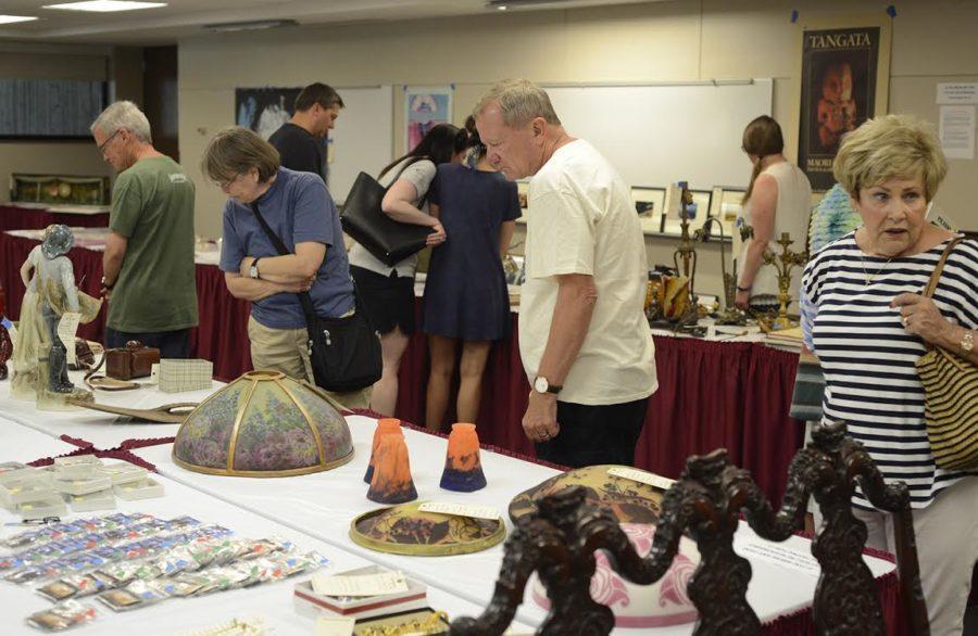 Visitors observe the various antiques the university museums are selling at the Arts and Antiques sale held on Friday. 