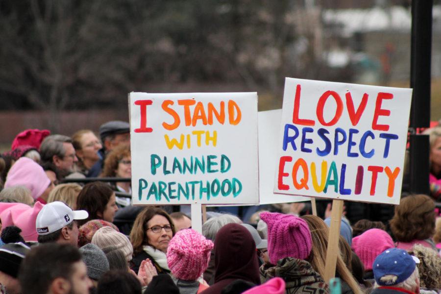 Protestors hold signs that read, I stand with Planned Parenthood, and Love, Respect, Equality, during the Womens March in Des Moines. Signs and speakers highlighted a variety of issues including LGBTQ+ rights, women’s healthcare and President Trump’s cabinet choices.