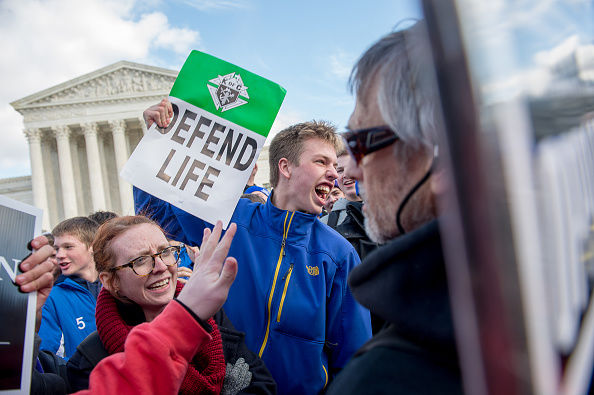 WASHINGTON, DC - JANUARY 22: Covington Catholic High School Freshman Tommy Smith of Cincinnati, Ohio, center, screams at a pro-choice protesters in front of the U.S. Supreme Court during the annual pro-life anti-abortion March for Life to protest the U.S. Supreme Court decision legalizing abortion in the case Roe v. Wade on January 22, 2015 in Washington, DC. (Photo by Andrew Harnik for The Washington Post via Getty Images)