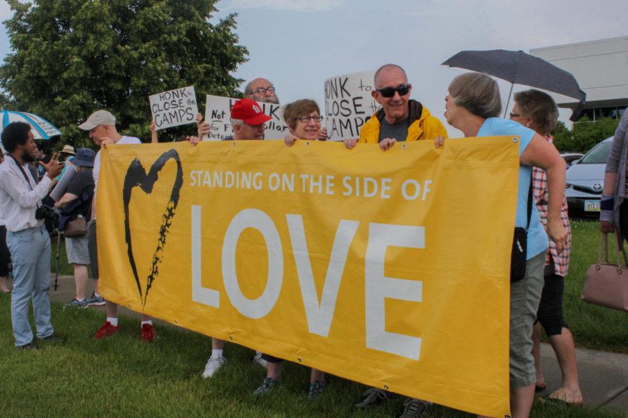 Protesters hold a banner up reading Standing on the Side of Love during the #CloseTheCamps protest outside of Rep. Steve Kings office on July 2. Protesters demonstrated outside Kings office for the closing of U.S. immigrant detention centers. 
