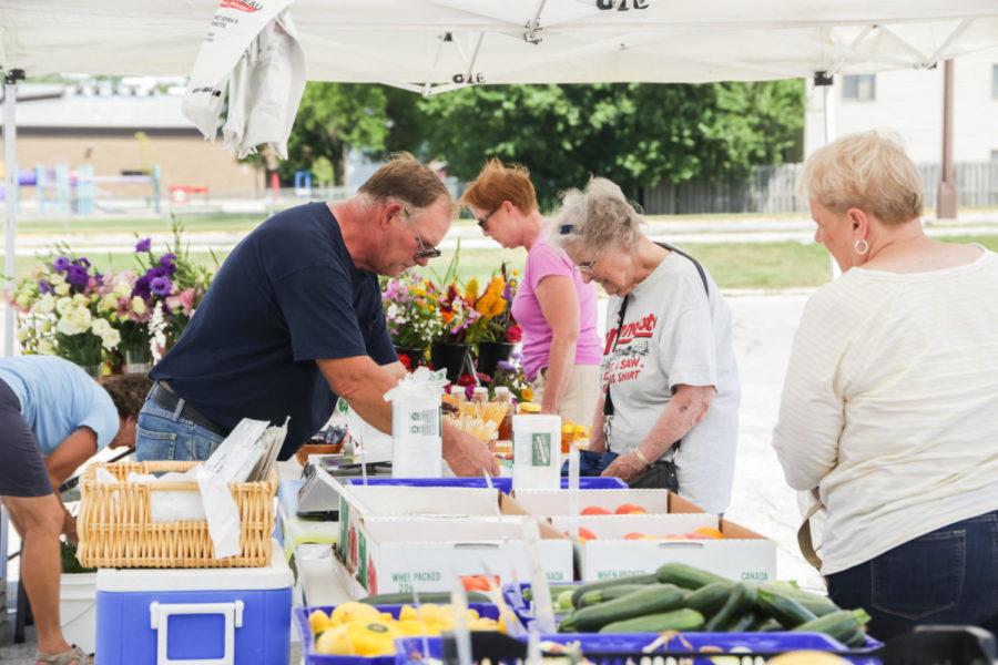 Members+of+the+Ames+community+gather+outside+of+North+Grand+Mall+July+18+for+the+Wednesday+farmers+market.+Booths+sold+everything+from+flowers+and+organic+produce+to+honey+and+beeswax.