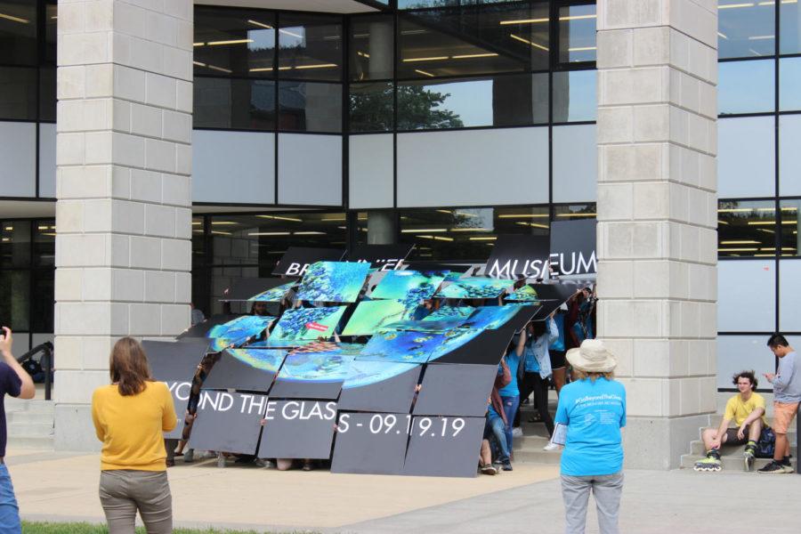Students participated in a freeze mob Monday in front of Parks Library. It culminated with a large art image promoting the upcoming Beyond the Glass Reopening Gala.