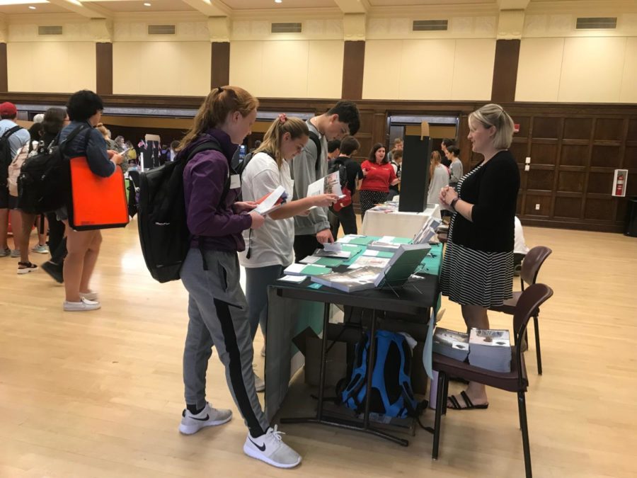 Students speak with a study abroad program representative and read information at the 2019 Study Abroad Fair.