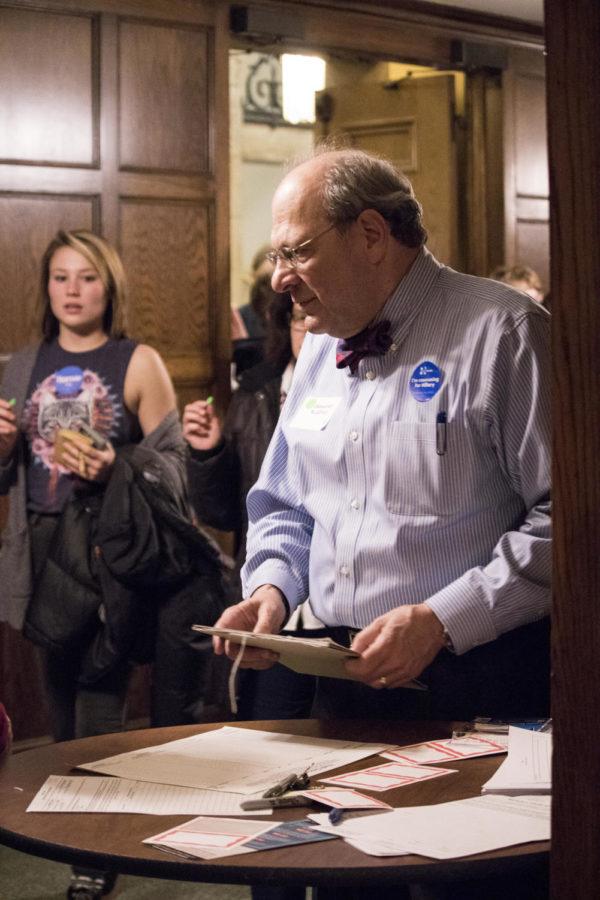 A caucus staffer hands out name tags to registered caucus voters Feb. 1, 2016, in the Memorial Union at Iowa State. The name tags guaranteed official caucus members were the only votes being counted.