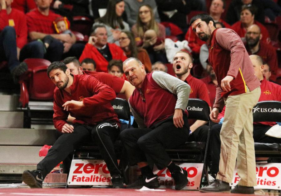 Iowa State wrestling assistant coach Derek St. John (left), head coach Kevin Dresser (middle) and assistant coach Brent Metcalf (right) watch intently as redshirt sophomore Jarrett Degen takes on South Dakota State junior Henry Pohlmeyer as a part of the 149-pound weight class. Degen won against Pohlmeyer in the third period. The Iowa State wrestling team won 47-0 against South Dakota State.